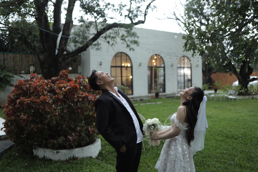 John and Alyssa laughing with their faces to the rain